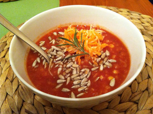 Rajčatová polévka s mrkví, celerem a lehce opraženými slunečnicovými semínky.